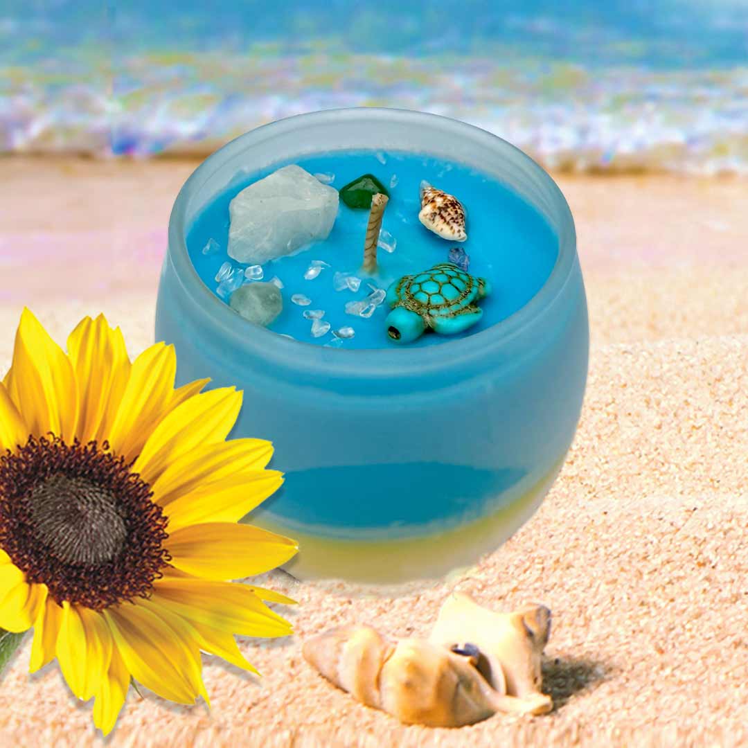 Blue and yellow candle  adorned with turtle, seashell, quartz, amazonite, aventuring on a beach setting with a sunflower.