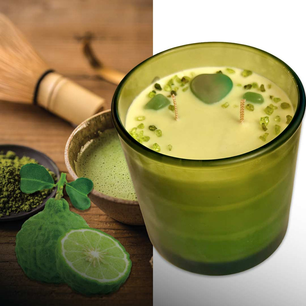 9 oz. Green candle in a green glass container with matcha powder, green leaves, and a bamboo whisk on a wooden surface. Aventurine heart with Peridot sprinkles. Two wicks. 