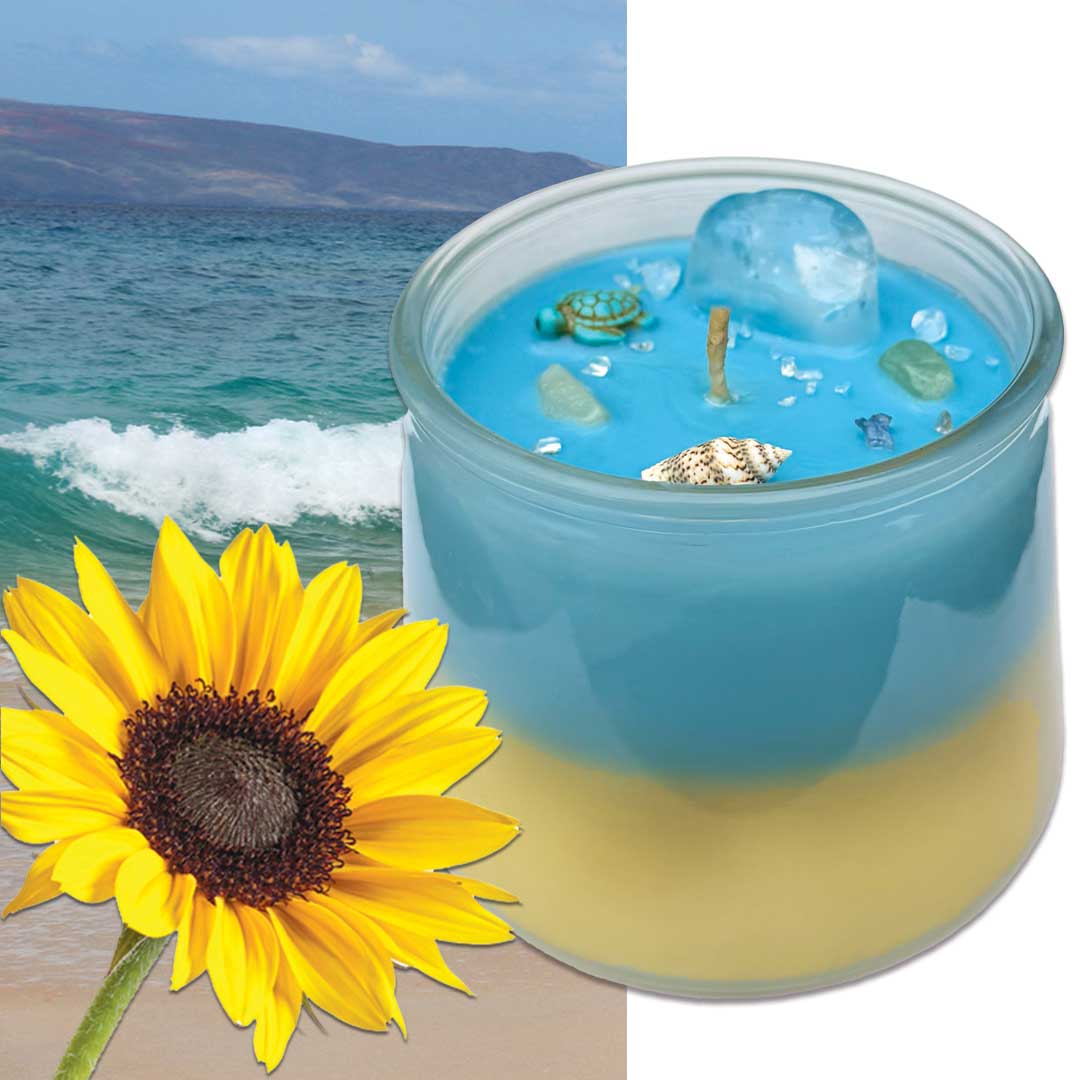 Candle with blue and yellow layers next to a sunflower and beach scene