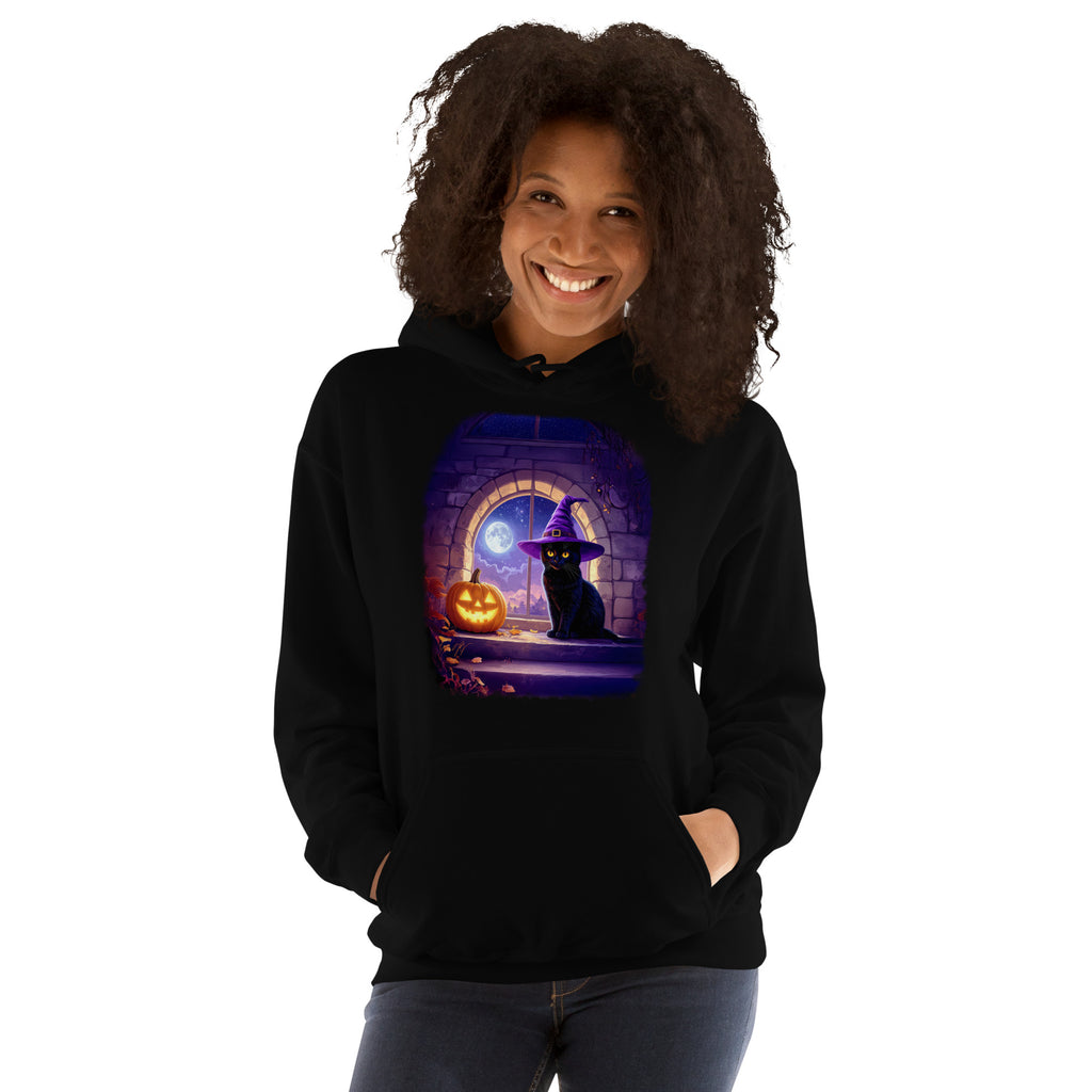 Woman wearing black hoodie with Wizard Kitten by the stone wall arched window with the full moon and a jack-o-lantern. 