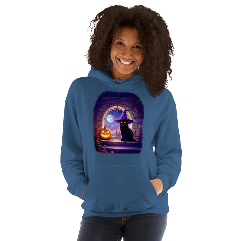 Woman wearing indigo hoodie with Wizard Kitten by the stone wall arched window with the full moon and a jack-o-lantern. 