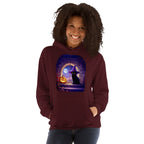 Woman wearing maroon hoodie with Wizard Kitten by the stone wall arched window with the full moon and a jack-o-lantern. 