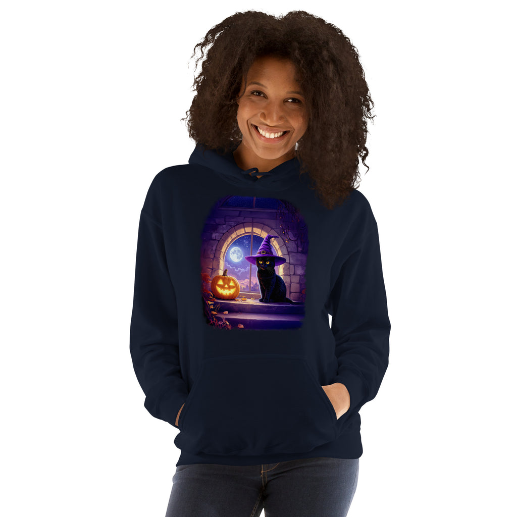 Woman wearing navy hoodie with Wizard Kitten by the stone wall arched window with the full moon and a jack-o-lantern. 