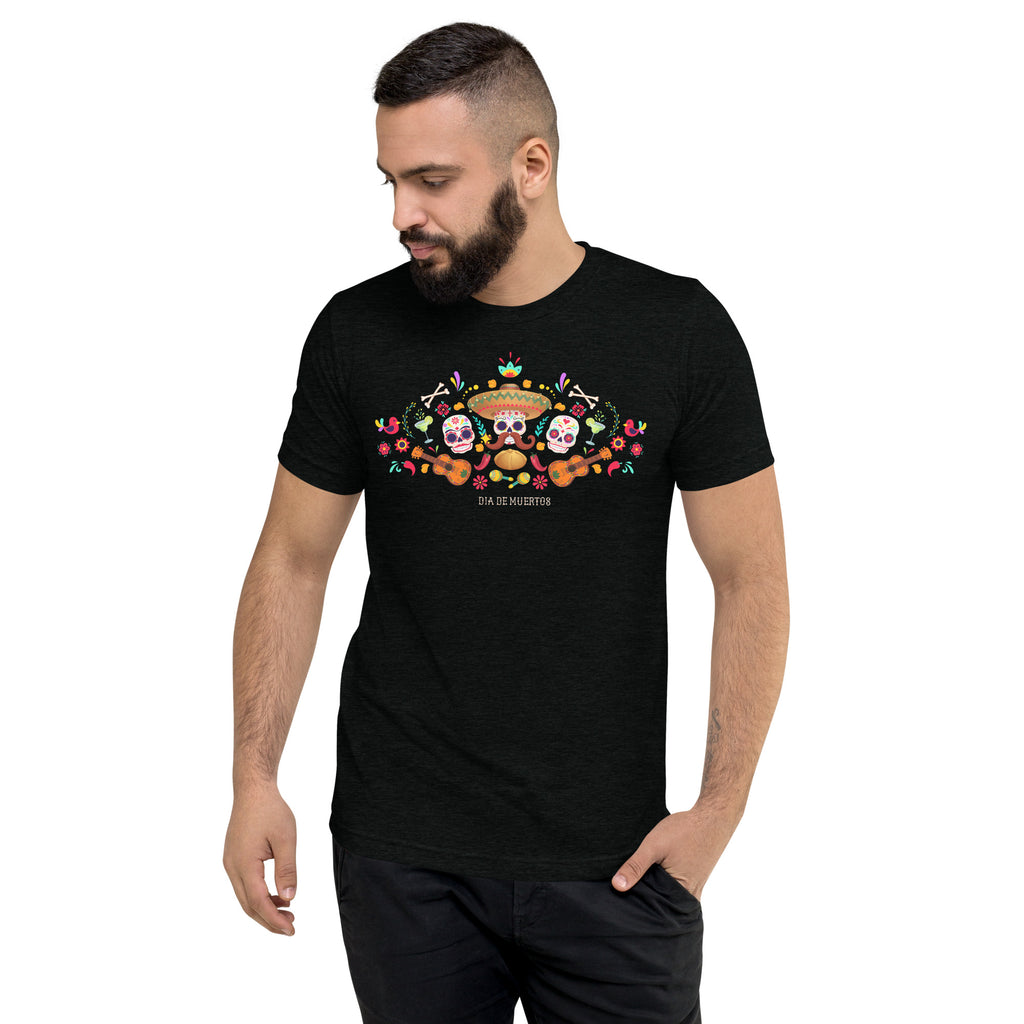 Man wearing a black t-shirt with a colorful graphic design of three amigo skulls with guitars, flowers and ornaments. 