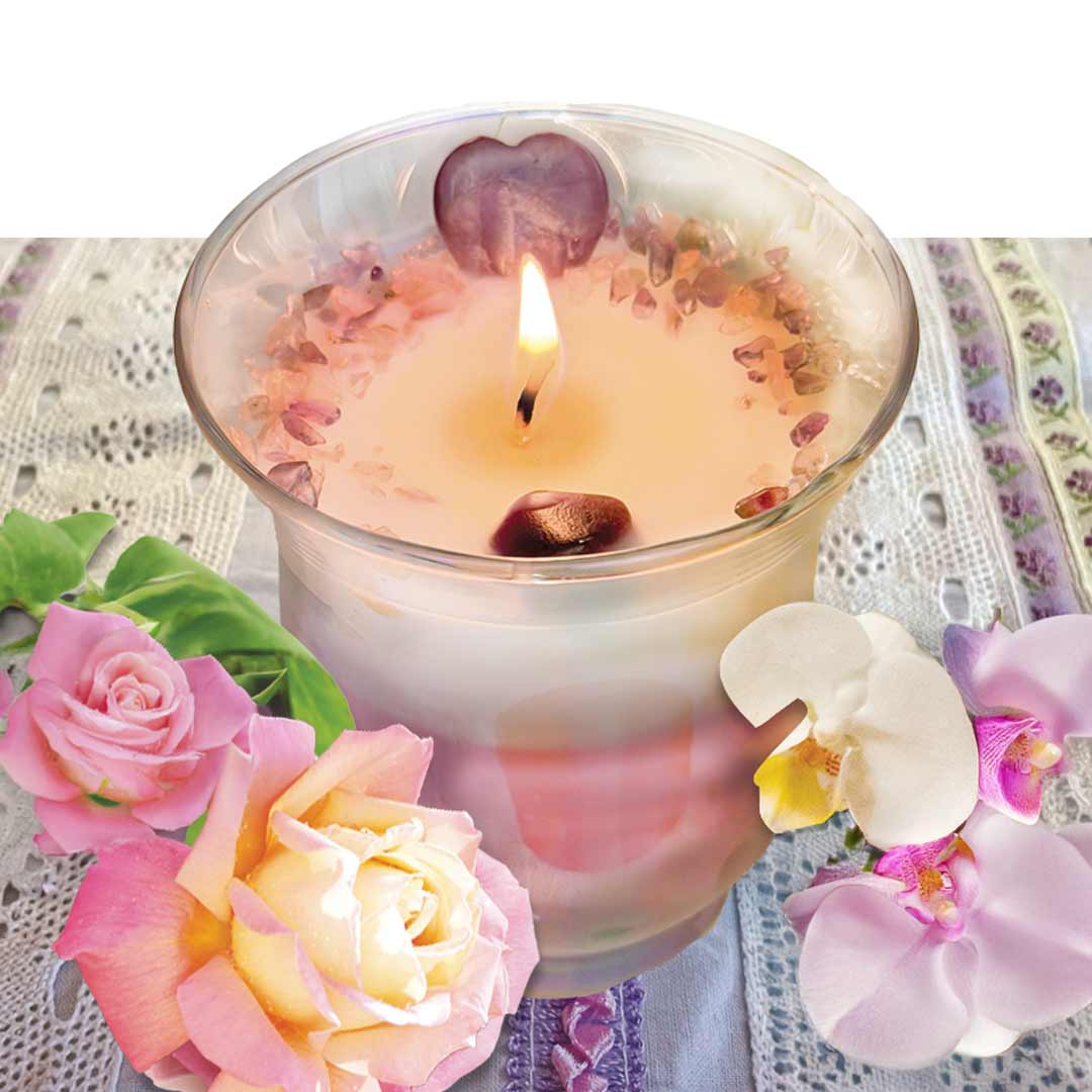 Tulip shaped vessel with white and pink layered wax. Adorned with a Amethyst heart and sprinkles in Amethyst and Rose Quartz. Surrounded by roses and orchids. 
